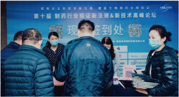 允咨会议协办活动现场,参会者在品牌背景板前交流